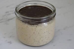 when to throw out sourdough starter — unhealthy sourdough starter in glass jar showing signs of contamination and inactivity